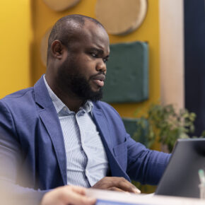Coworkers evaluating sales infographics on interactive board presentation, look into annual data reports to understand what needs to change in order to achieve international success.